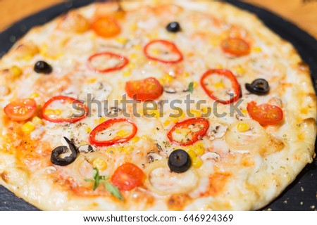Vegetarian meatless pizza on a dark background with mushrooms, cheese and sweet pepper.