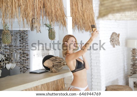 Girl taking selfie in the tropical bar