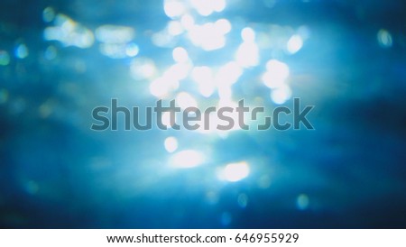 Beautiful underwater sea scene view with natural light rays, shining through the water's glittering and moving surface