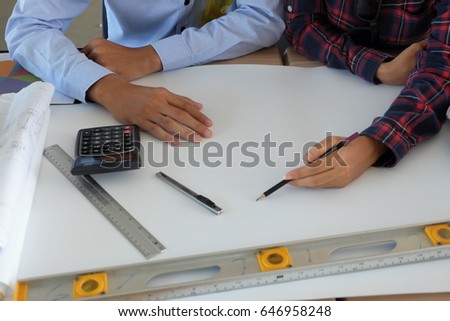 Architect and businessman are planning  meeting to work , construction engineer looking  blueprint on table ,construction engineer, team of professional engineers working with blueprints