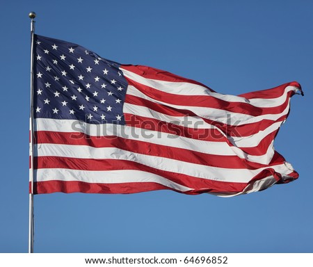 Large U.S. Flag "Old Glory" blowing in a strong wind on a cloudless day