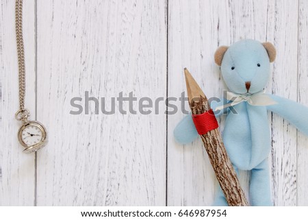 Stock Photography flat lay vintage white painted wood table blue bear doll holding pencil pocket clock