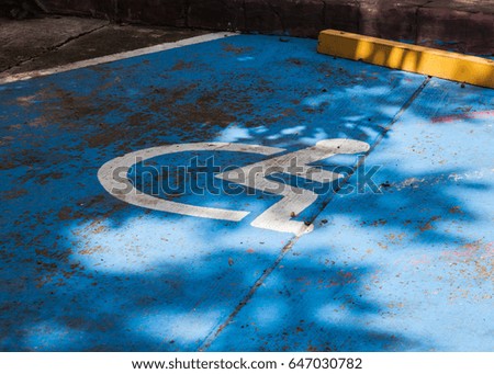 Sign of a person with a disability on the asphalt.