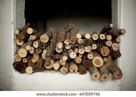 Stacked wood in a window recess with white background, geometric, abstract, natural, textural