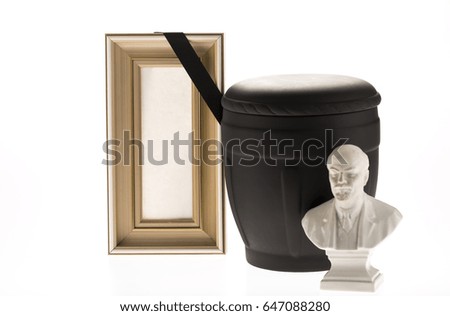 Black cemetery urn with blank mourning frame on bright background