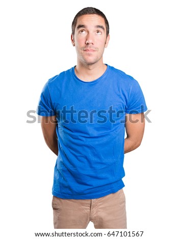 Astonished young man looking up against white background