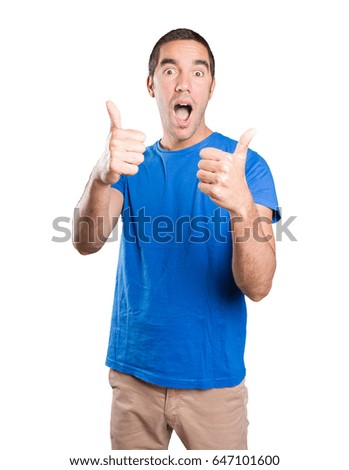 Happy young man with okay gesture against white background
