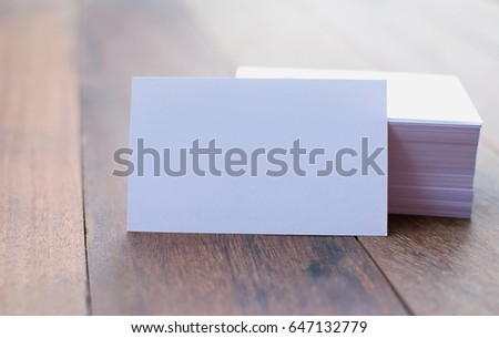 White business card piled high on the floor brown wood.