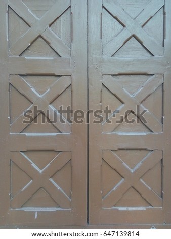 vintage brown door that has cross symbol on it.