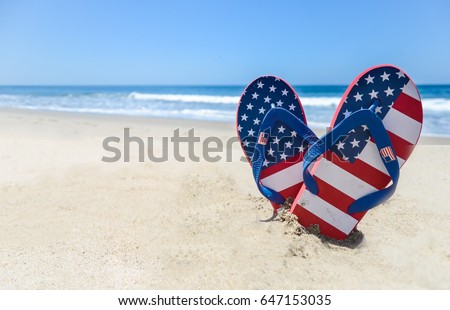 Patriotic USA background with flip flops on the sandy beach Royalty-Free Stock Photo #647153035