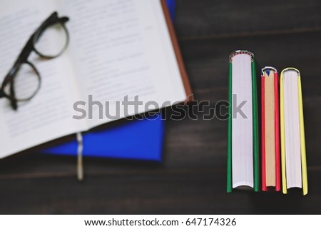 Book with glasses on table,picture style top view.
