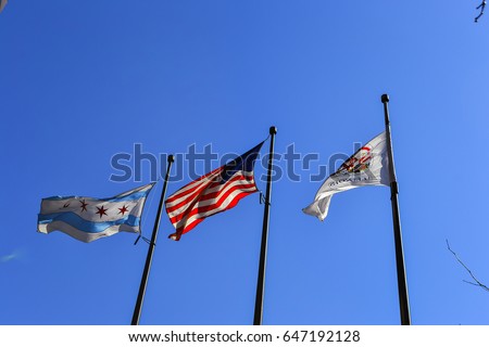 Illinois State Flag, US Flag, and Chicago Flag waving in breeze.