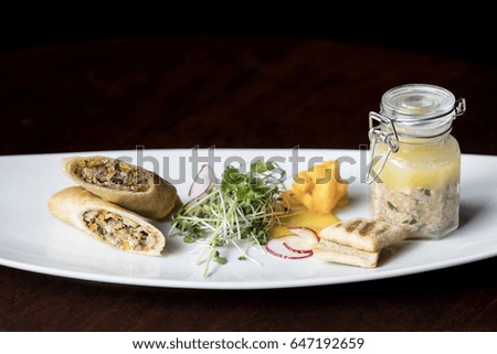 Spring rolls with Rabbit Pate and Salad Served on a white plate with immaculate presentation