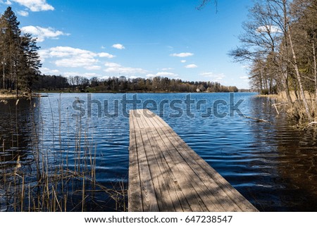 reflection of clouds in the lake with boardwalk and blue skies in background