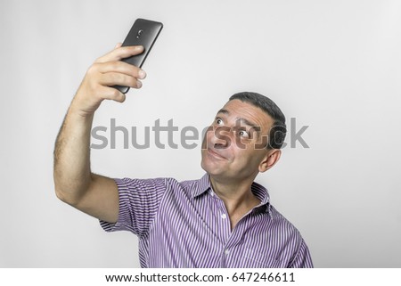 funny man takes selfie on a white background