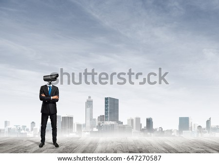 Faceless businessman with camera zoom instead of head against cityscape background
