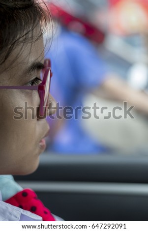
The students wear glasses to play phone, morning on the street on a signal light. Rain in the morning traffic on road congestion.