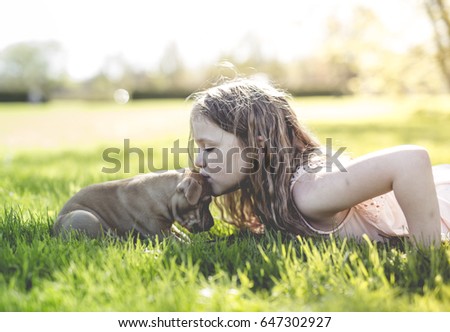 A Cute little girl holding her funny boxer dog