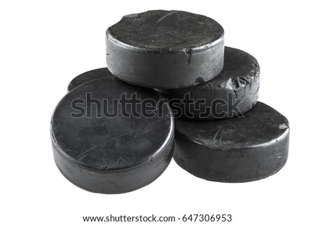 A stack of five used hockey pucks isolated on a white background.