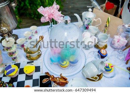 Holiday themed table for the tea ceremony. Table with sweets. Tea with sweets. Table of Alice in Wonderland
