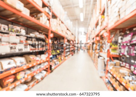 Blur hardware store in America. Defocused home improvement retailer, rack of drywall tools, join compound, rebar, deck boards, stair parts, wet/dry vacuums, tool boxes, child safety, building material