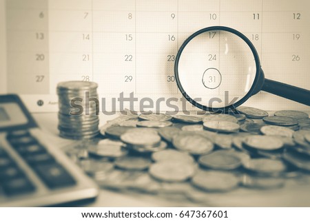 magnifying glass focus on deadline calendar with some coin and calculator in foreground, overdue, reminder concept  Royalty-Free Stock Photo #647367601