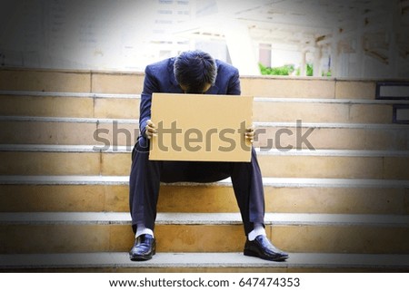 Businessman is losing. He is holding card board for your own text