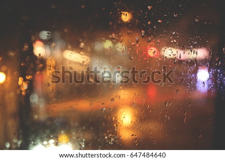 Rainy season.rain drops on a window with the color of light bokeh