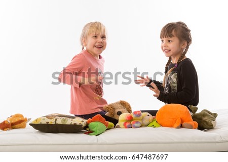 The twins are playing on the couch, isolated on white background