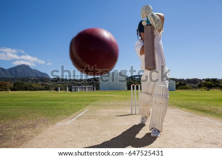Full length of batsman playing cricket on pitch against blue sky during sunny day