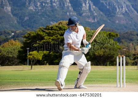 Full length of cricket player playing on field during sunny day