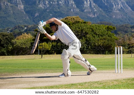 Full length of cricketer playing on field during sunny day Royalty-Free Stock Photo #647530282