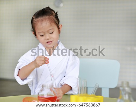 Asian child in scientist uniform holding test tube with liquid isolated on white background, Scientist chemistry and science education concept.