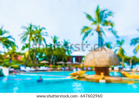 Abstract blur coconut palm tree around swimming pool in hotel and resort for background