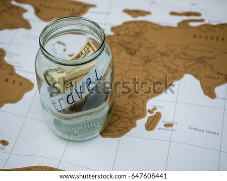 A glass jar with money standing on the map. Travel inscription. Concept, idea