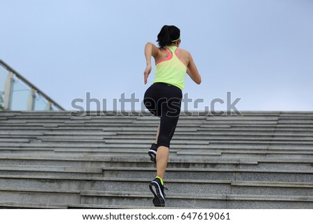 Sporty female running up on stone stairs