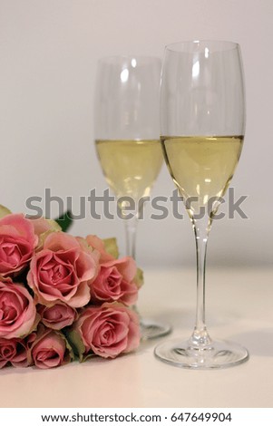 Two classes of champagne with bouquet made of pink roses