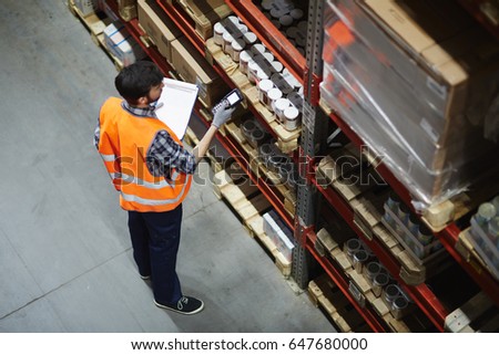 Logistics dispatcher scanning barcodes on packs with goods Royalty-Free Stock Photo #647680000