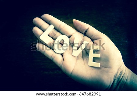 Wood love word in woman hand,Love concept