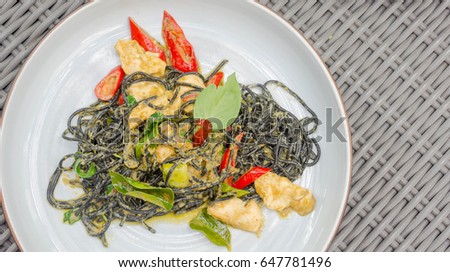 selective focus point black spaghetti with curry chicken - fusion food thai style