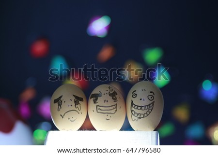 cry angry and happy faces on 3 egg shells and many color bokeh 