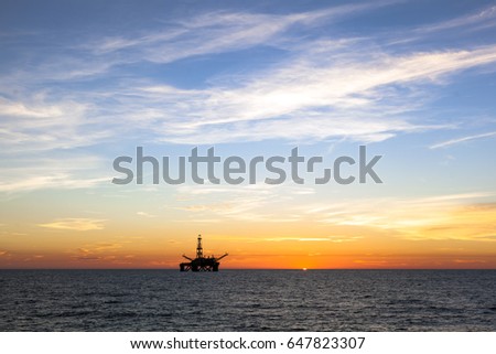 Silhouette of an offshore oil platform at sunset 