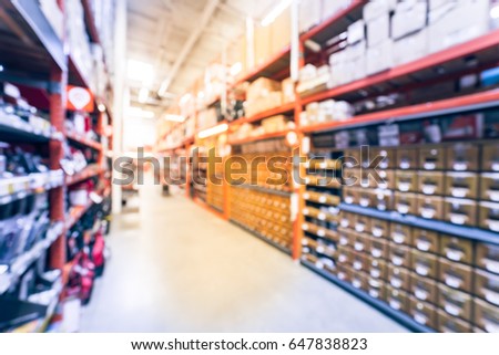 Blur hardware store in America. Defocused home improvement retailer with rack of drywall tools, join compound, rebar, deck boards, stair parts, wet/dry vacuums, tool boxes, child safety. Vintage tone.