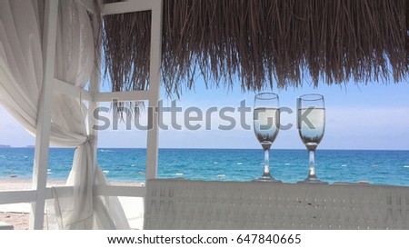 Two glasses of champagne on the beach with white sand on the terrace Royalty-Free Stock Photo #647840665