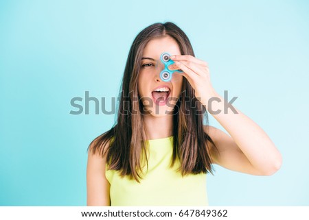 Girl playing with a fidget spinner Royalty-Free Stock Photo #647849362