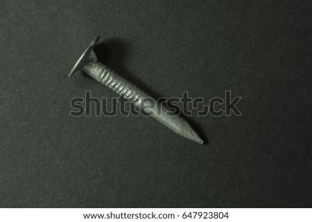 Macro of a diagonal strong nail isolated on dark background
