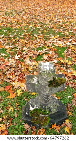 Nineteenth century cross gravestone and autumn lawn