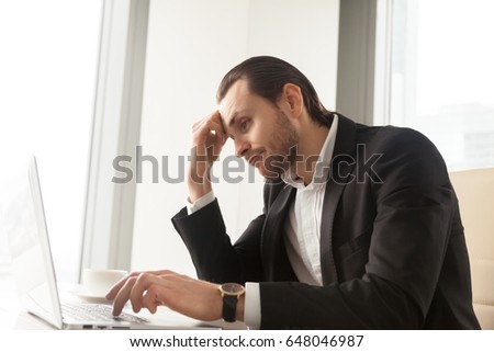 Young businessman at desk tired from routine laptop work. Entrepreneur boring at workplace, sick of monotonous work. Office worker procrastinates while trying complete dull report. Lack of motivation Royalty-Free Stock Photo #648046987