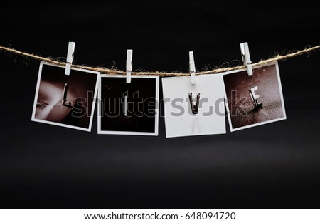 Rows of LIVE photo frames hanging with clothespins on dark background
