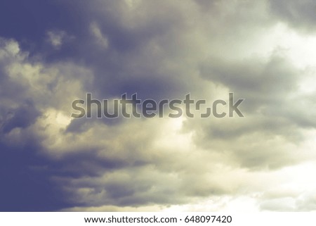 Dramatic seascape, dark clouds over blue sky.